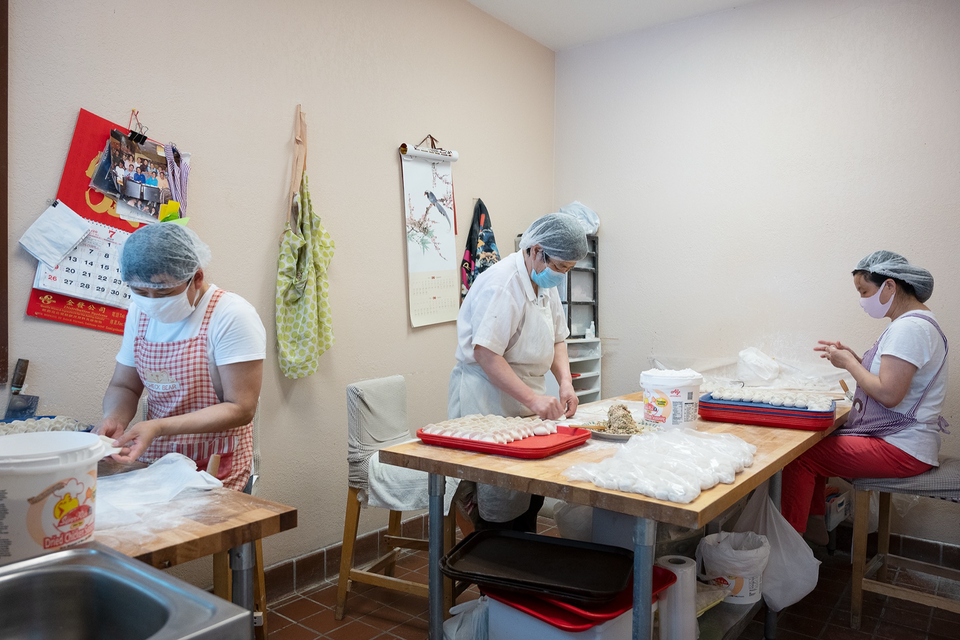 Kitchen staff assembling and packaging dumplings together